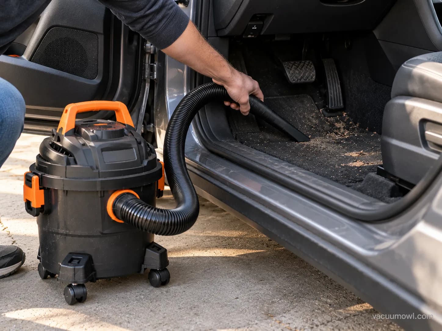Armor All wet dry vac cleaning a car interior footwell.