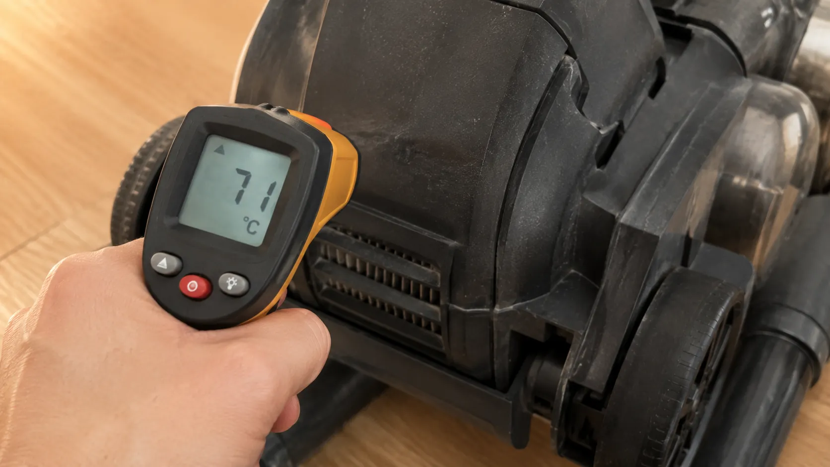Infrared thermometer showing 71°C on the motor housing of a Bissell CleanView vacuum when the thermal protector activates.
