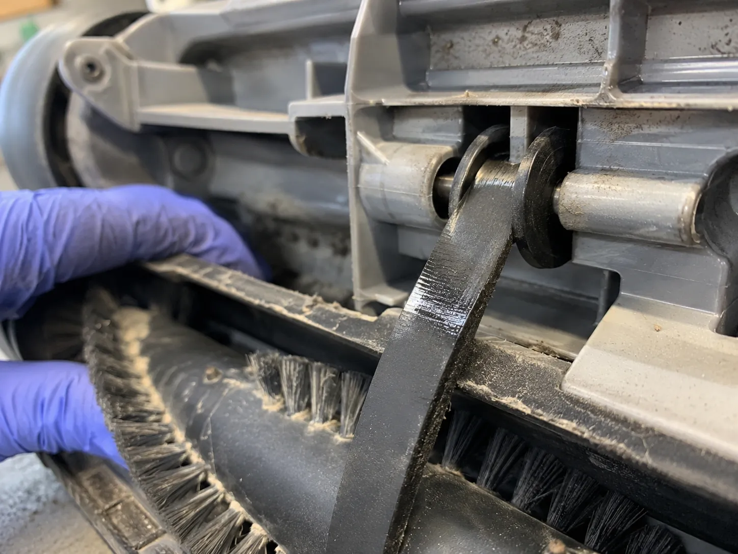 Flat-spotted Bissell CleanView Swivel Pet drive belt looped over the motor shaft after running against a jammed brush roll during a repair test.