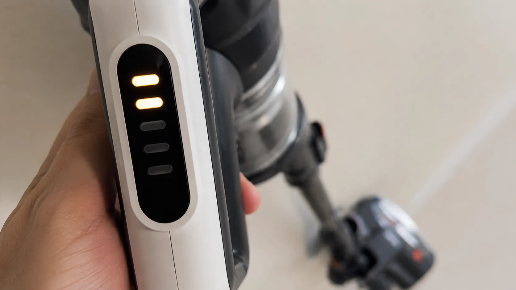 Close-up of a Bissell ICONpet 22889 vacuum light panel showing two illuminated segments for a brush roll stall warning.