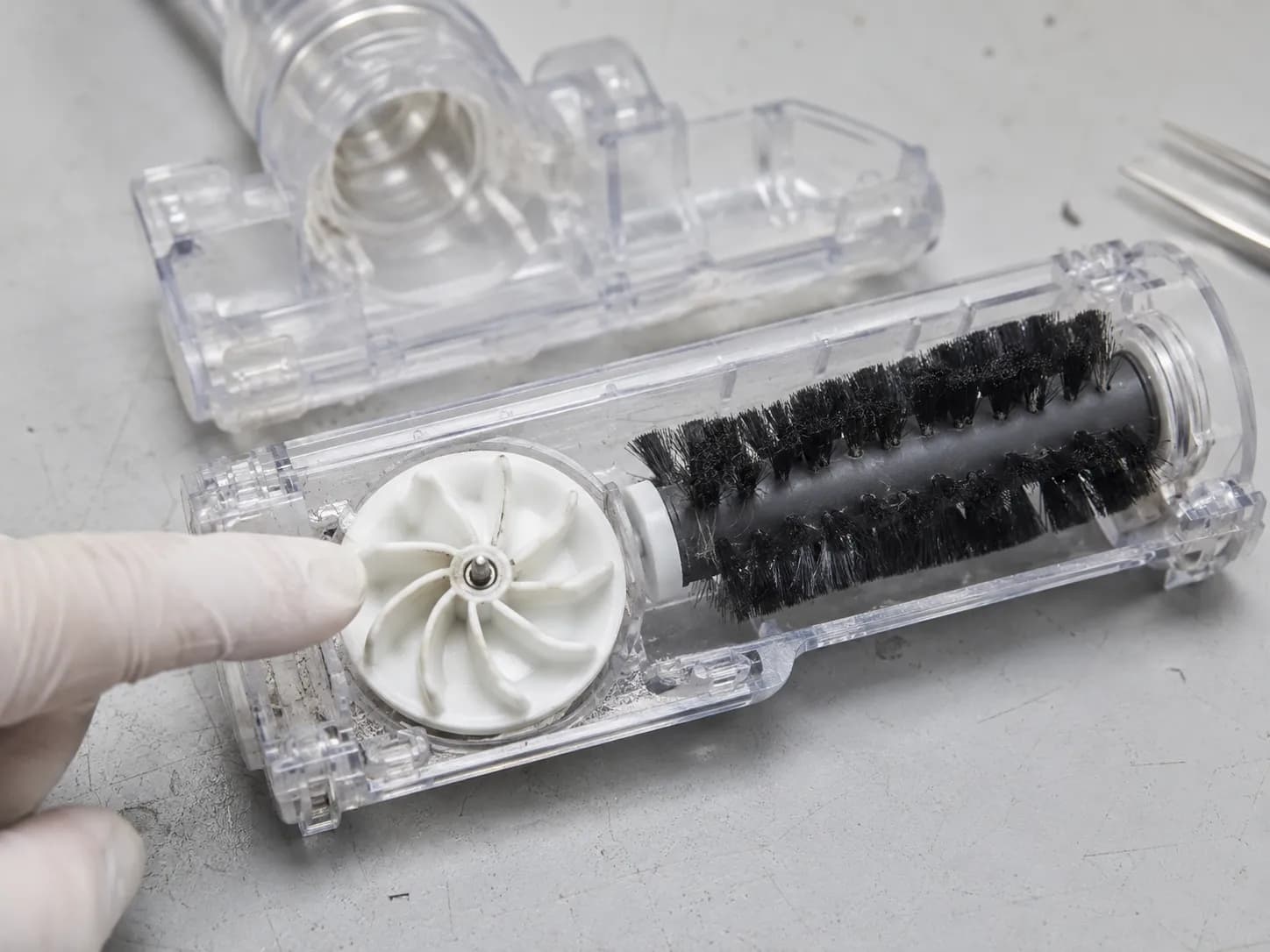 Opened Bissell turbo brush attachment showing the white vaned impeller that drives the brush roll with suction, demonstrating that a slow turbo brush is not motor-driven.