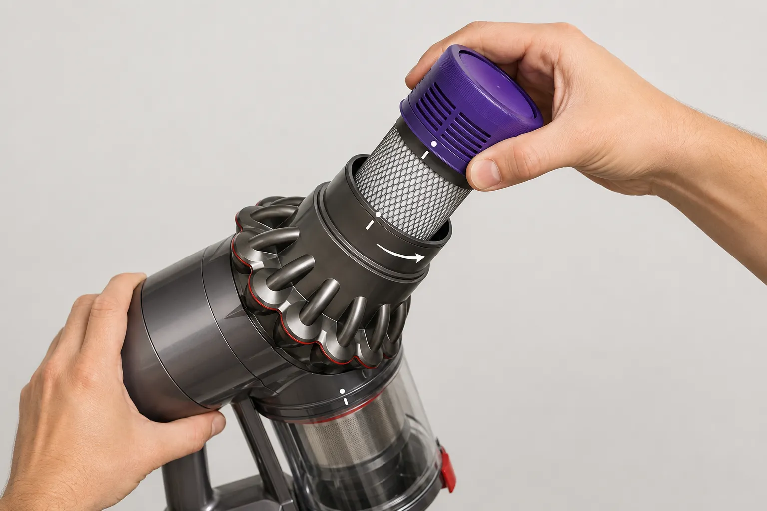 Two hands twisting a Dyson V10 filter clockwise into the vacuum with the alignment marks lined up correctly.
