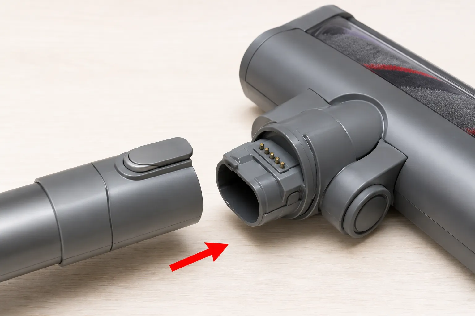 Close-up of Dyson vacuum wand and cleaner head contact points with a red arrow showing where to press the parts back together to reseat the electrical connection.