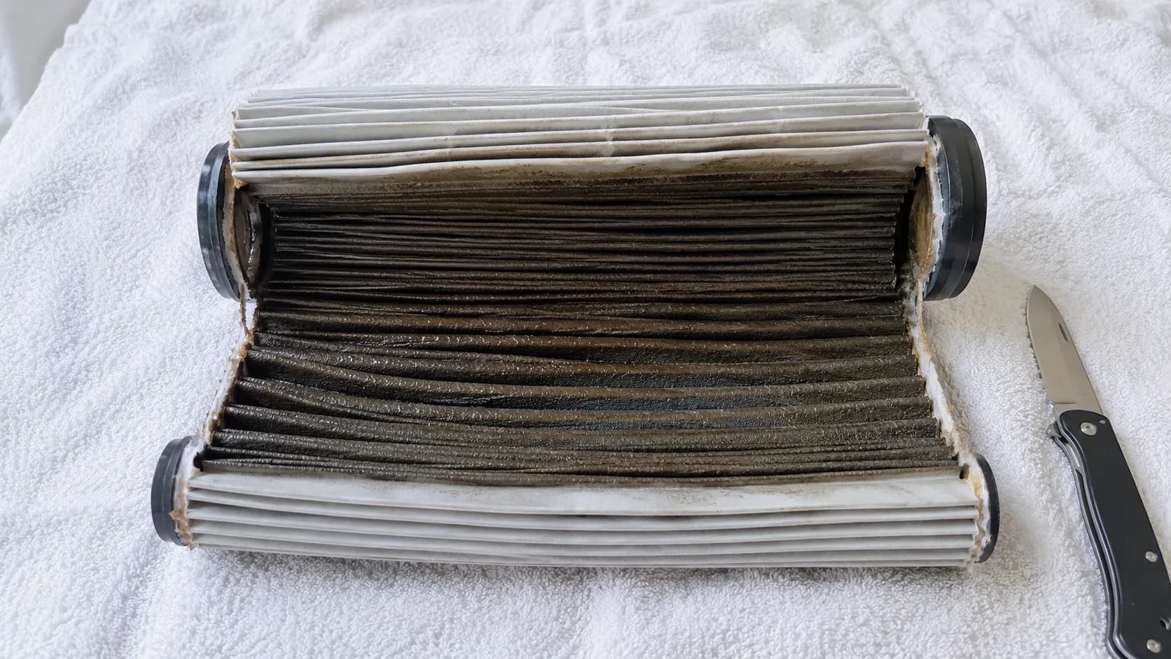 Cut-open washable vacuum filter showing dry outer pleats but a darker, still-damp interior after six hours of drying.