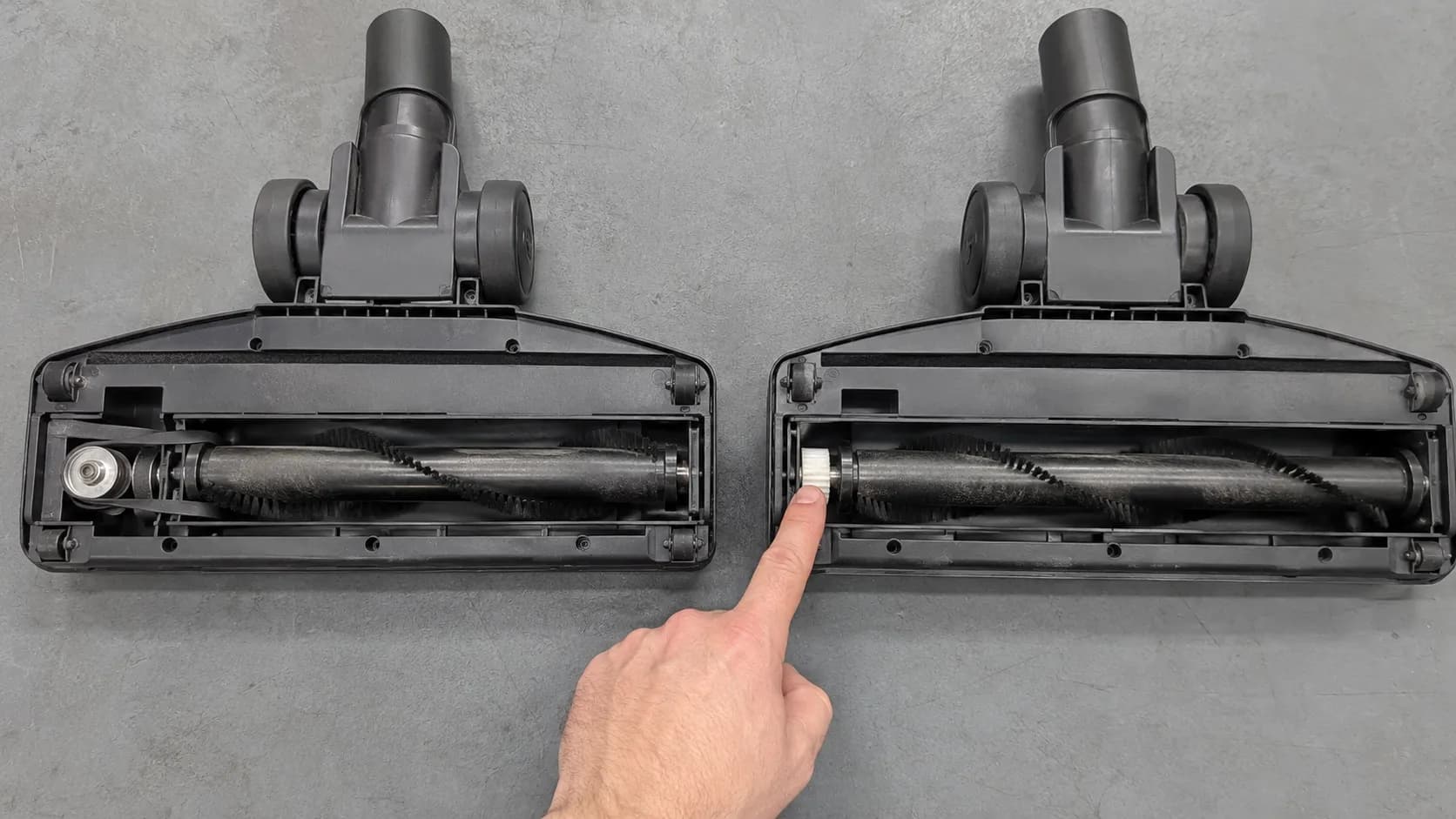 Side-by-side underside view of two vacuum nozzles, showing a flat belt and metal pulley on the left and a toothed gear drive with no belt on the right.