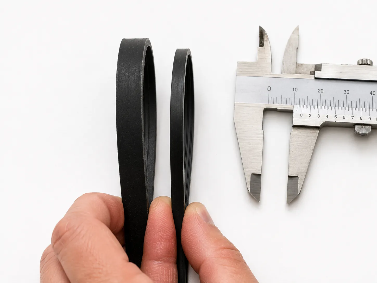 genuine OEM vacuum belt next to a thinner aftermarket belt showing the thickness difference