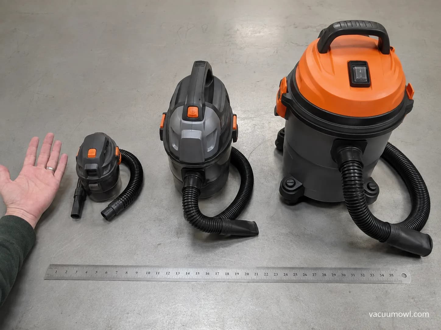 micro handheld and compact small shop vac sizes compared with a ruler and hand on a workbench