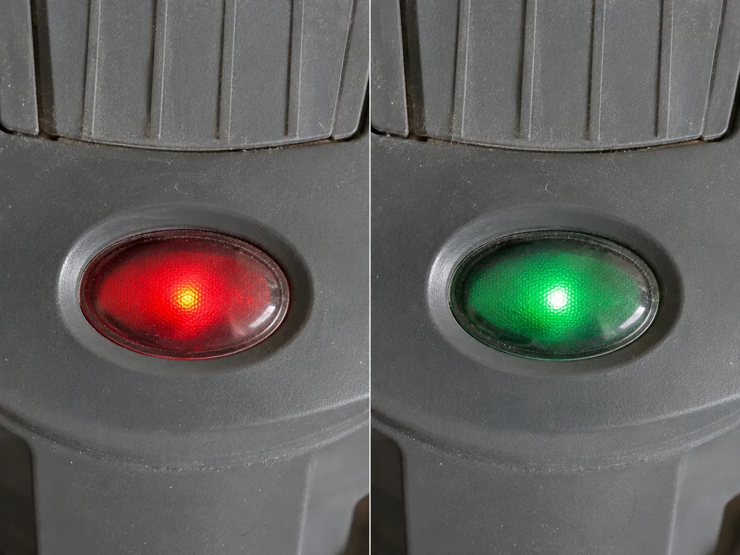 Close-up comparison of the same vacuum cleaner indicator light glowing red and then green four seconds later without the reset button being pressed.