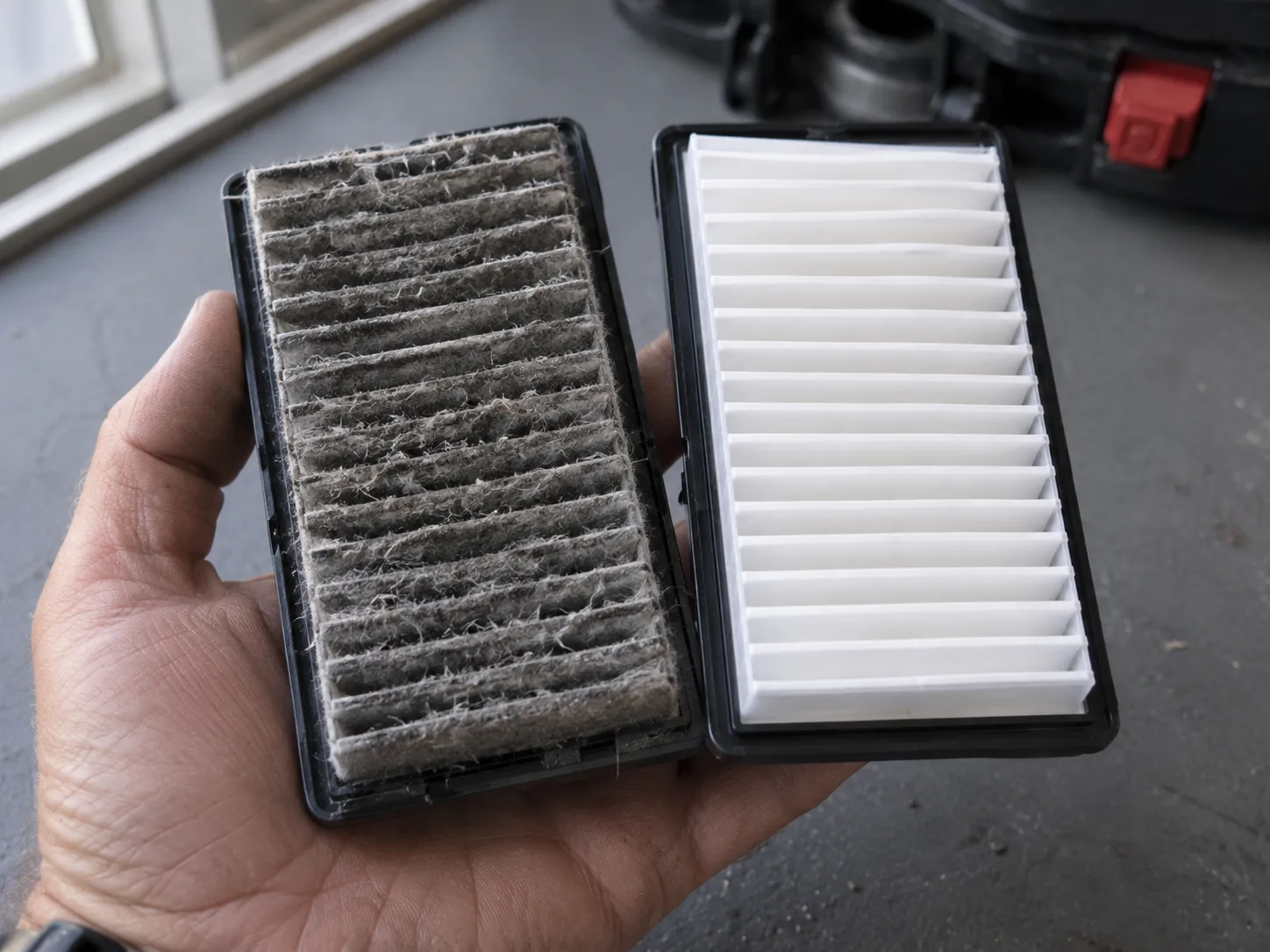 Dirty Bissell pre-motor filter matted with grey dust held beside a clean replacement filter for comparison.