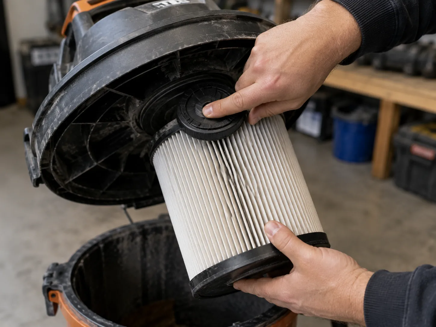 Hand pressing the Qwik-Lock nut to remove a RIDGID shop vac cartridge filter.