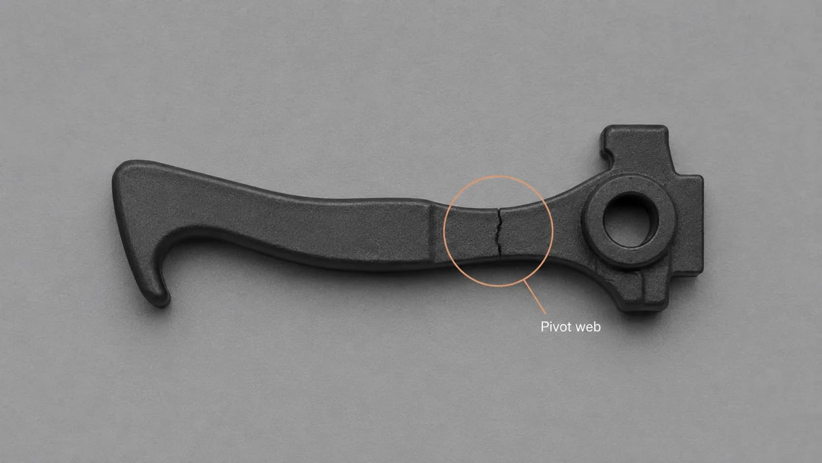 Annotated macro image of a cracked Dyson V10 trigger lever, with the pivot web circled to show the thin section where the part usually fails.