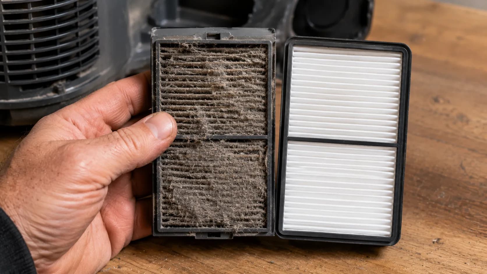 Clogged grey vacuum exhaust filter beside a clean white replacement filter