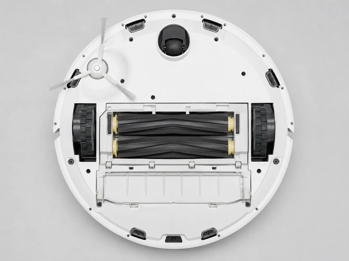 Underside of an i series Roomba showing the edge-sweeping brush, dual rubber extractors, brush guard and yellow roller end caps.