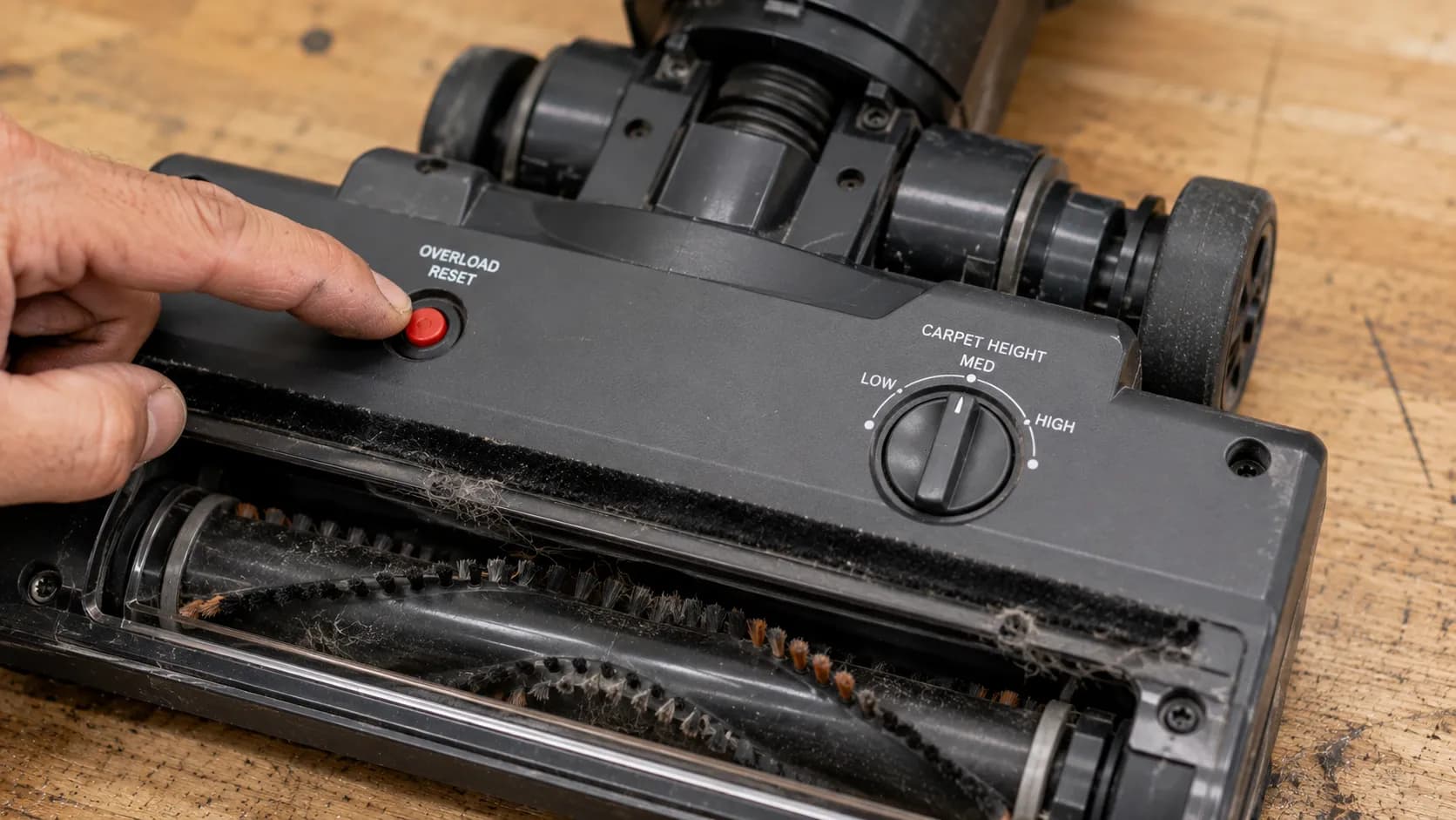 Vacuum power head overload reset button and carpet height selector.