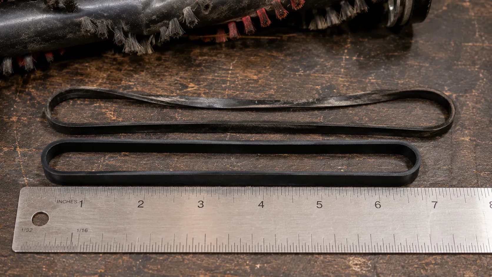 a stretched vacuum belt measured against a new one on a ruler